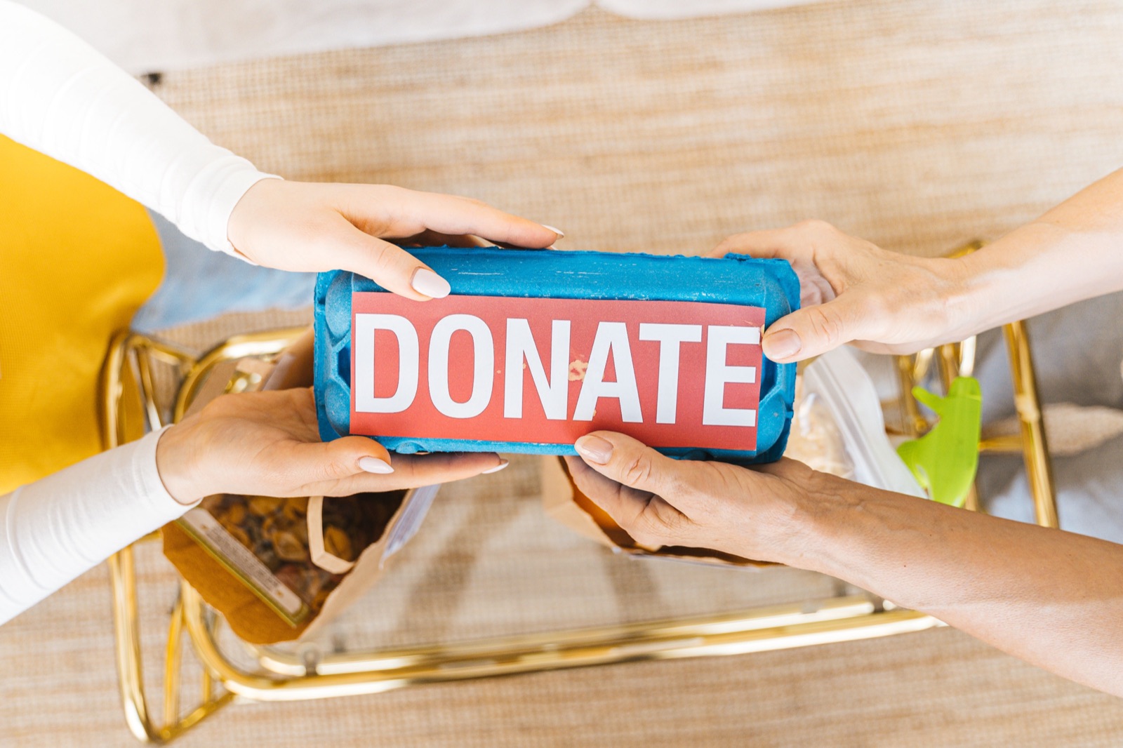 Two people passing a donation box between them
