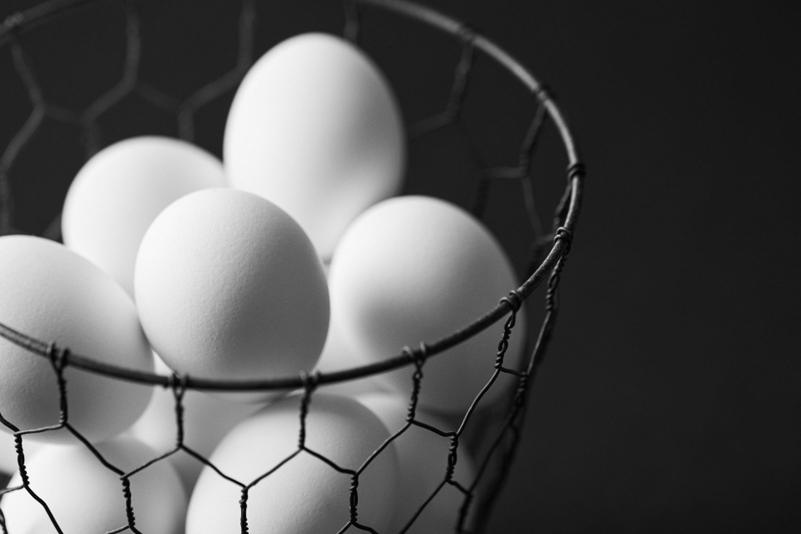 White eggs piled high in a black wire basket